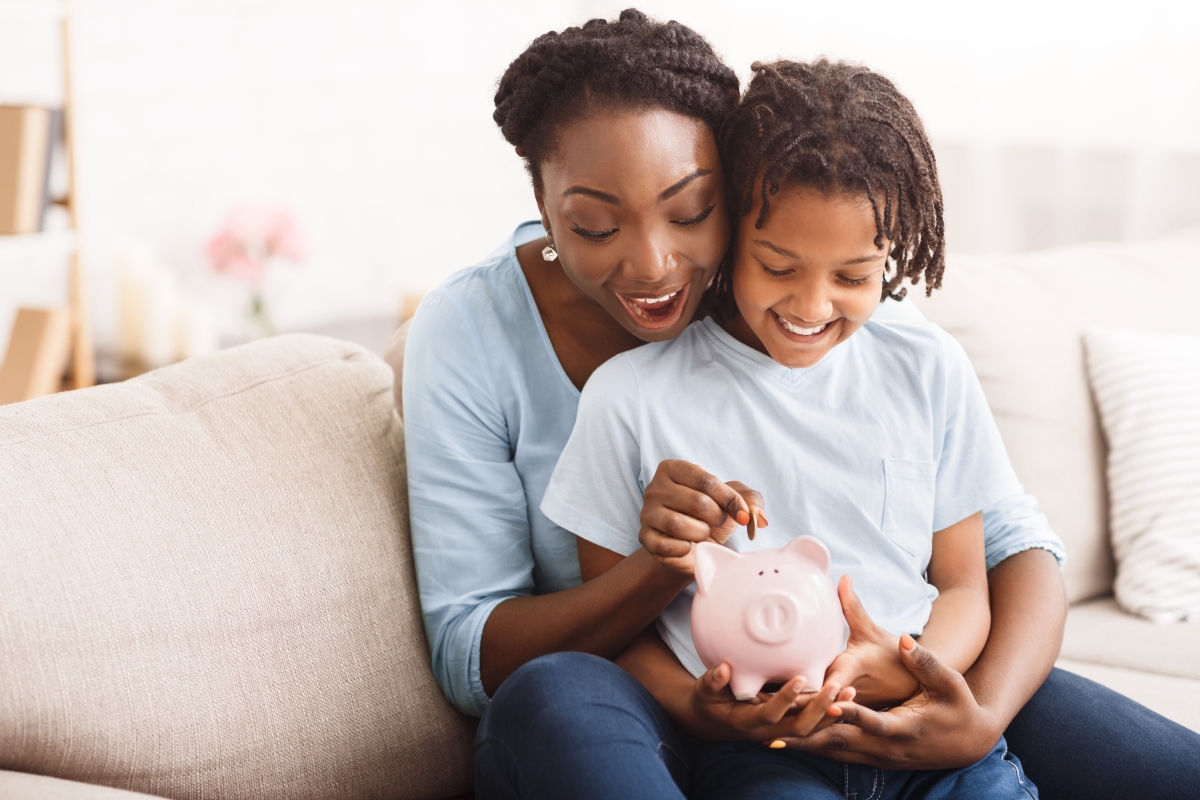 a mom and child talk about saving money with a piggy bank